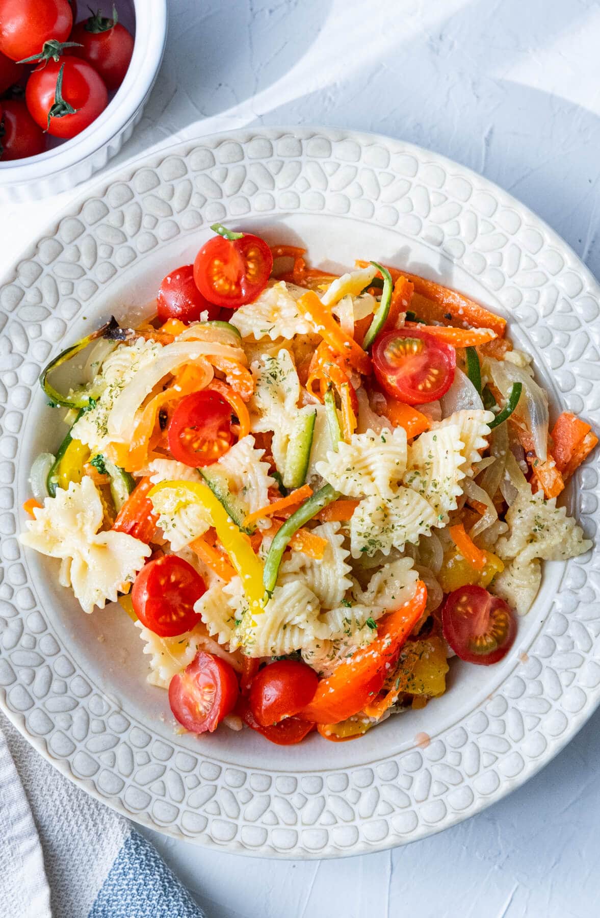 Baked carrot slices, zucchini, onion, bell peppers tossed together with farfalle pasta and topped with dried Italian herbs and grated parmesan cheese. 