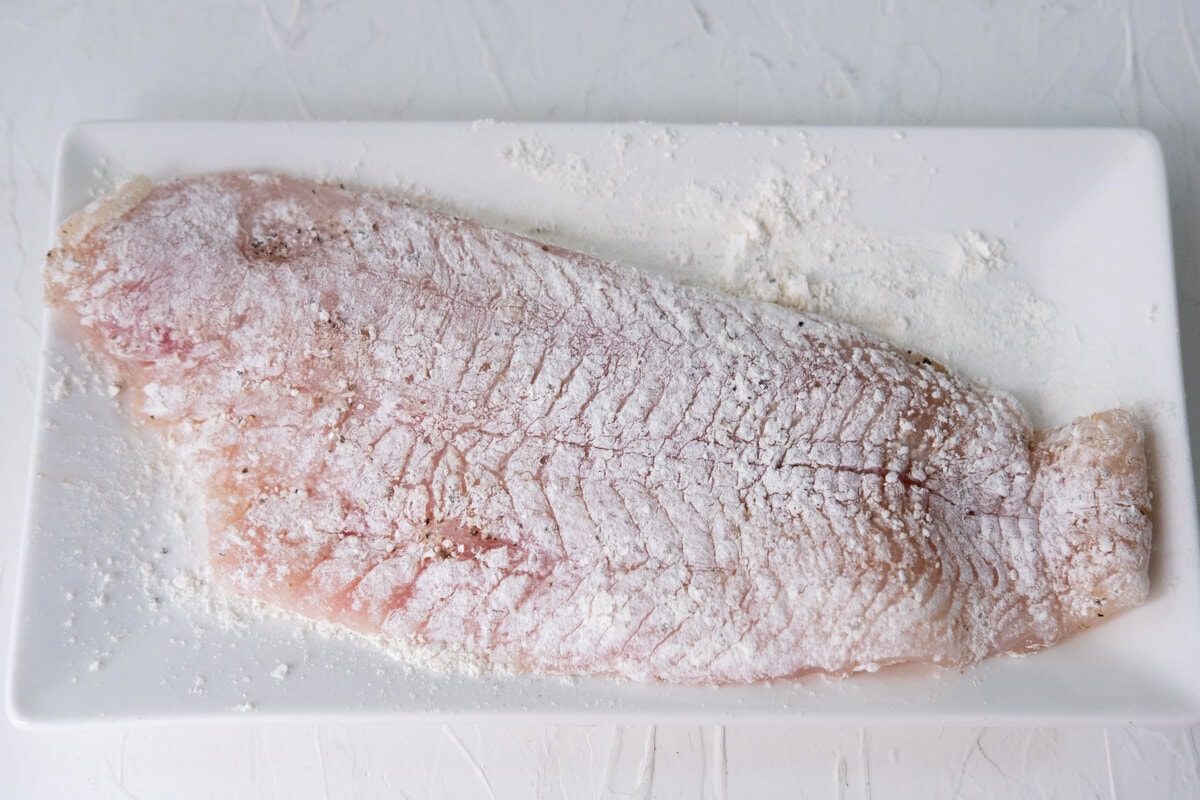 Coated the flounder fillet with all-purpose flour and sprinkled salt and ground black pepper on top. 