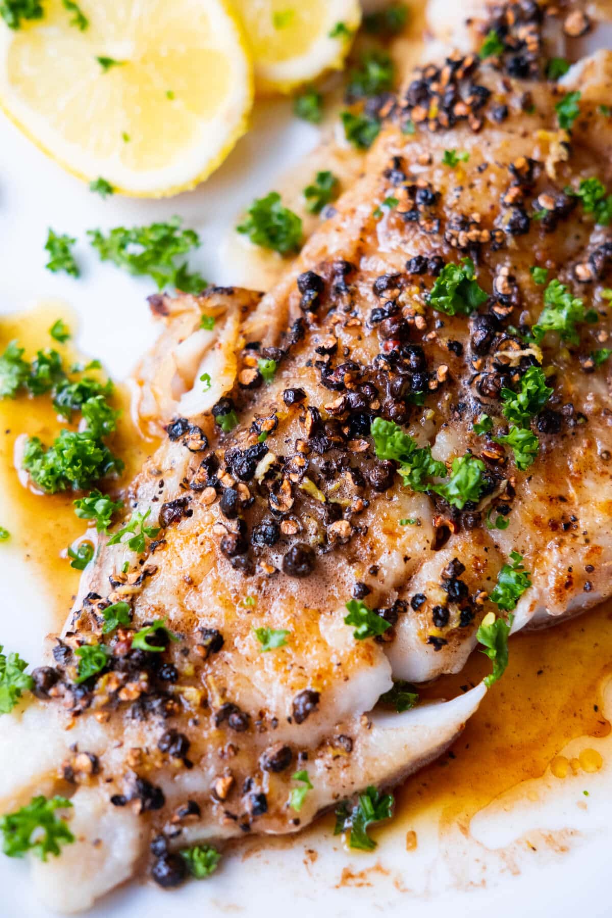 Crispy seared fish topped with crushed black peppercorns and drizzled with buttery sauce. 