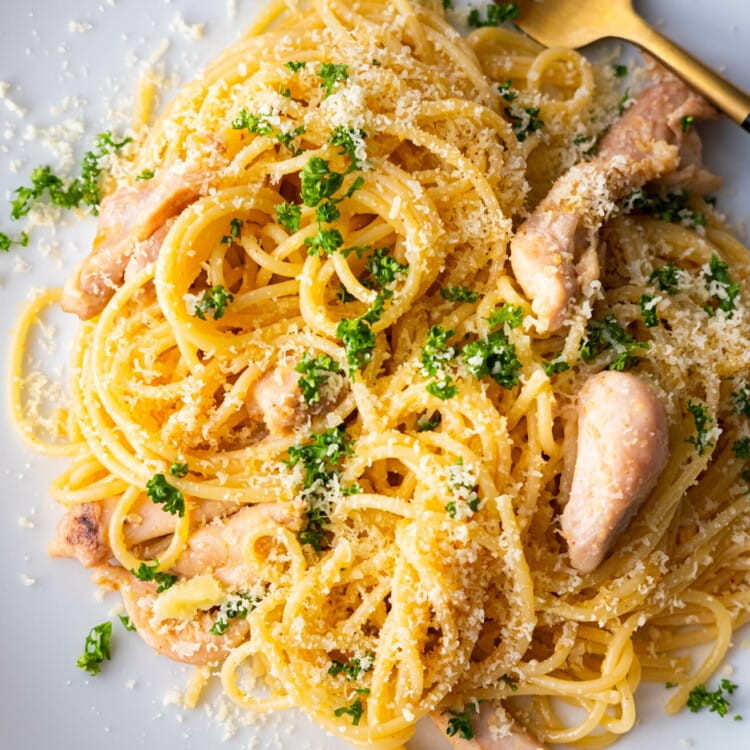 Spaghetti with tender chicken slices and sprinkled with grated parmesan and chopped parsley.