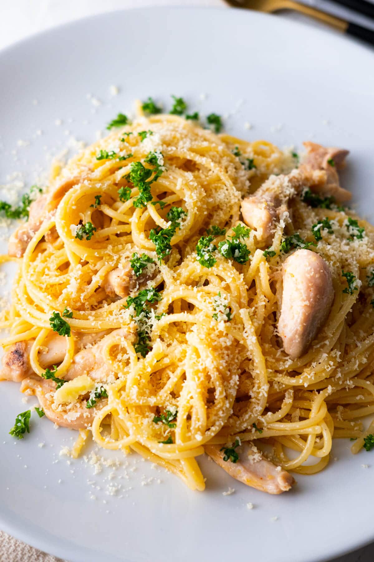 Chicken scampi pasta garnished with grated parmesan and chopped fresh parsley.