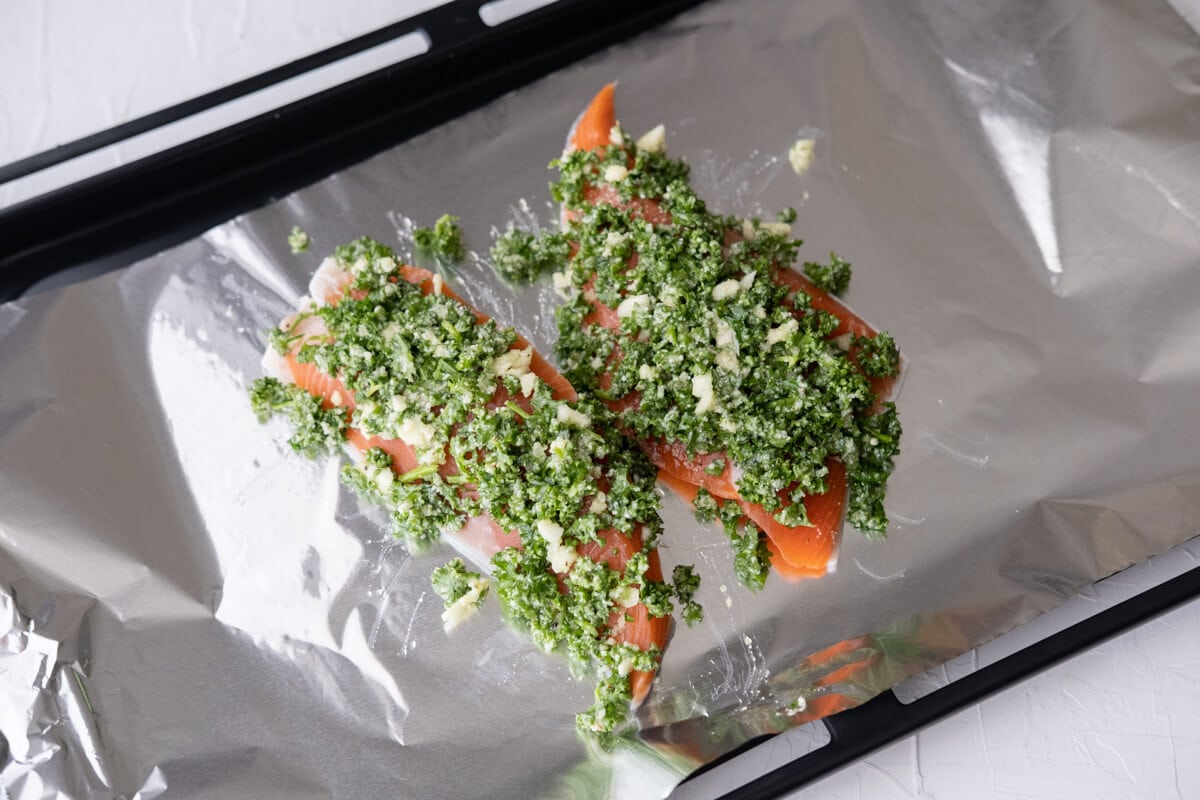 Place two salmon fillets on a baking sheet lined with foil and topped with parsley mixture. 