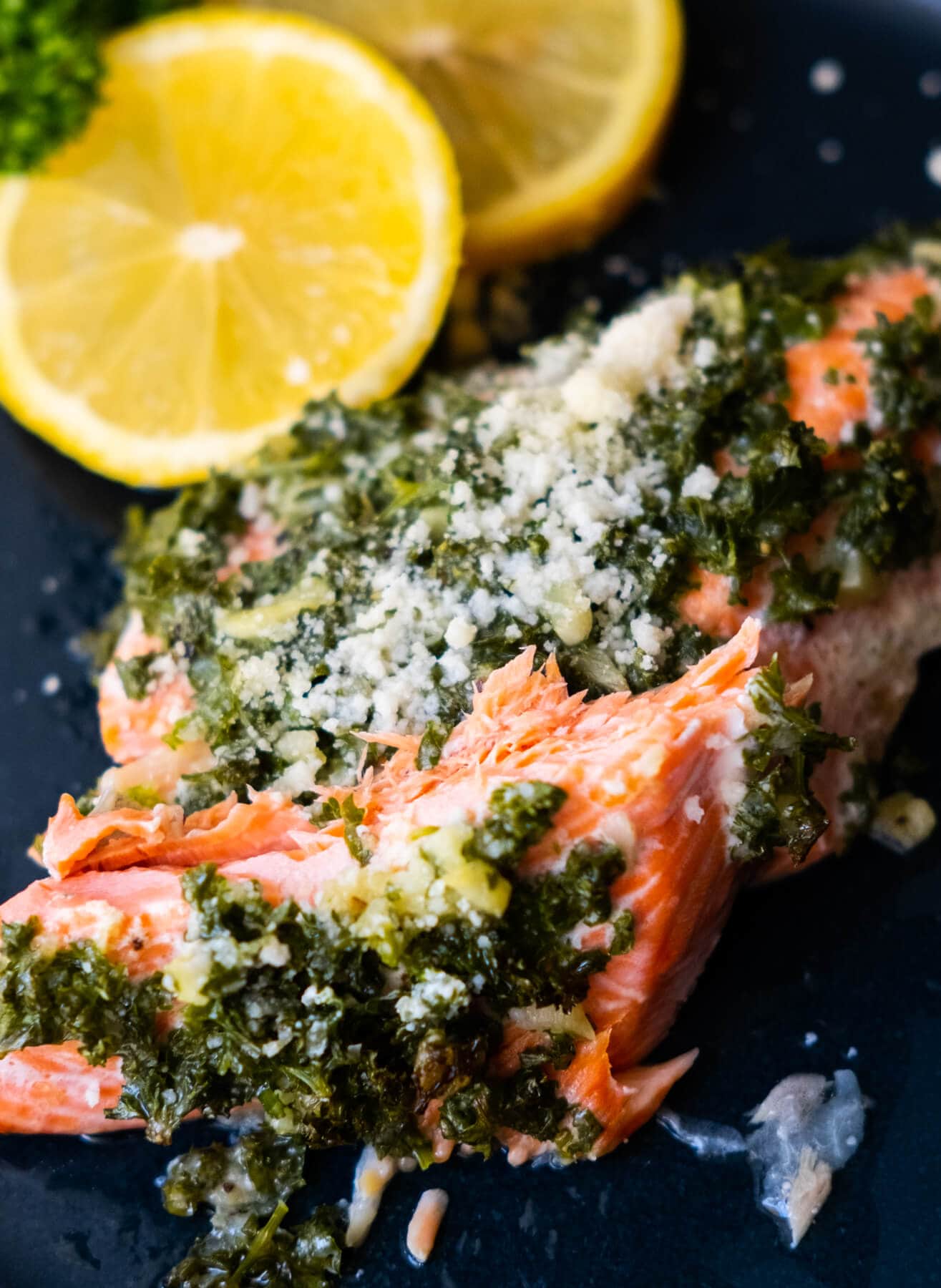 Baked salmon split in half with grated parmesan and parsley mixture on top. 