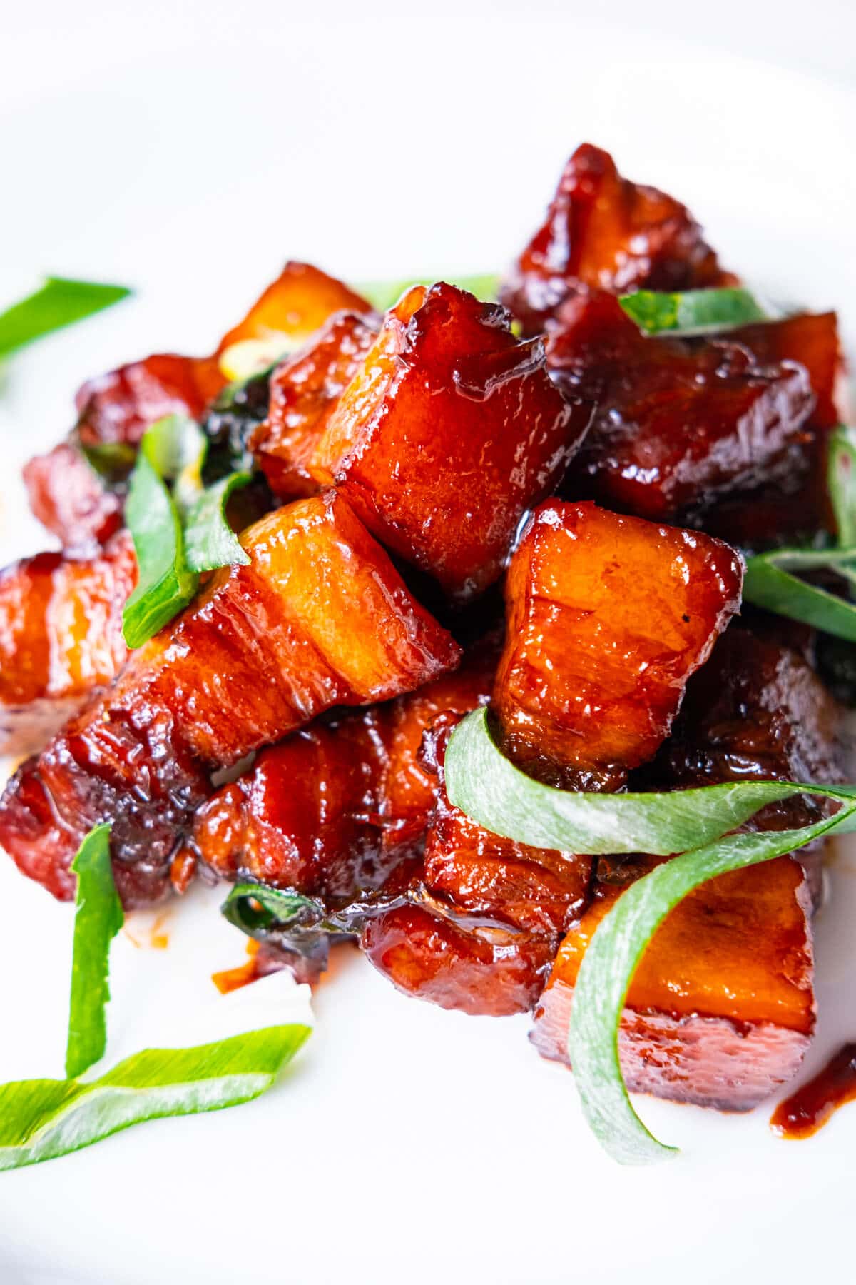 Tender braised pork belly shows clear layer of lean meat and fat. 