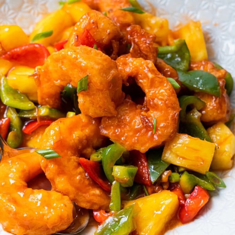 Sweet and sour shrimp lightly coated in red tomato sauce mixture and served together with small pieces of green and red bell pepper and pineapple.
