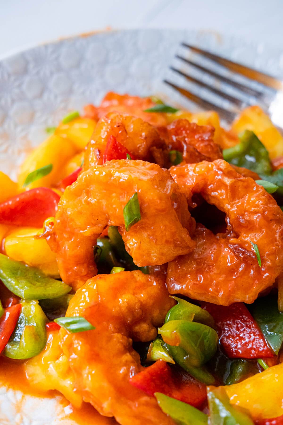 Close up on shrimp coated with sweet and sour sauce. 