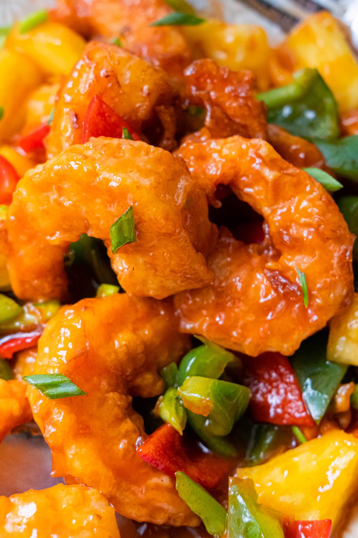 Close up on crispy shrimp and sprinkled with chopped scallion. 