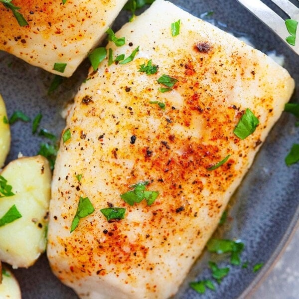 Juicy and moist oven baked cod fish served on a plate.