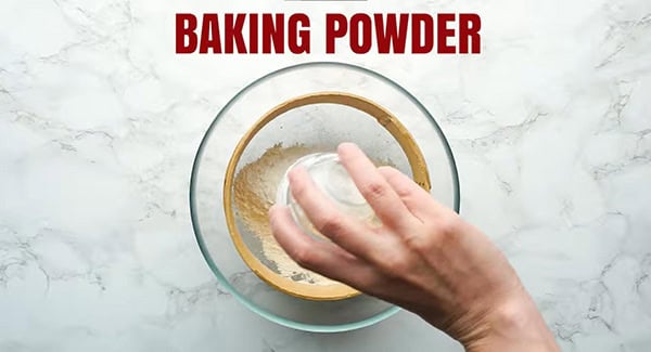 Sifting all-purpose flour and baking powder in a bowl.