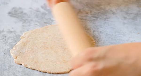 This image shows the Chapati being rolled out with a rolling pin.