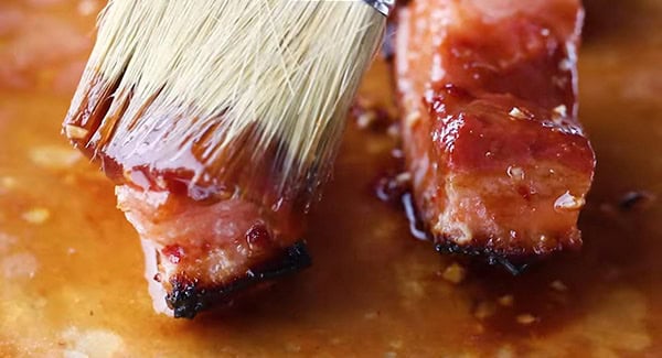 This image shows the Pork Belly being brushed with the Char Siu Sauce.