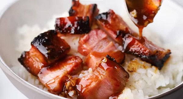 This image shows the Char Siu being served over white rice.