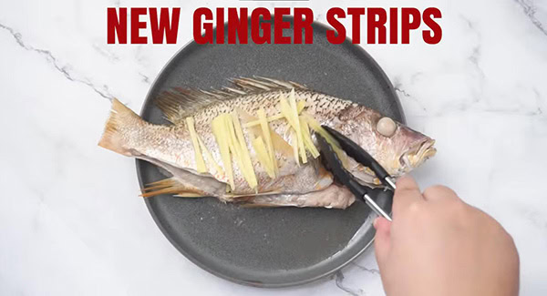 This image shows the fish after steaming and placing new ginger strips.