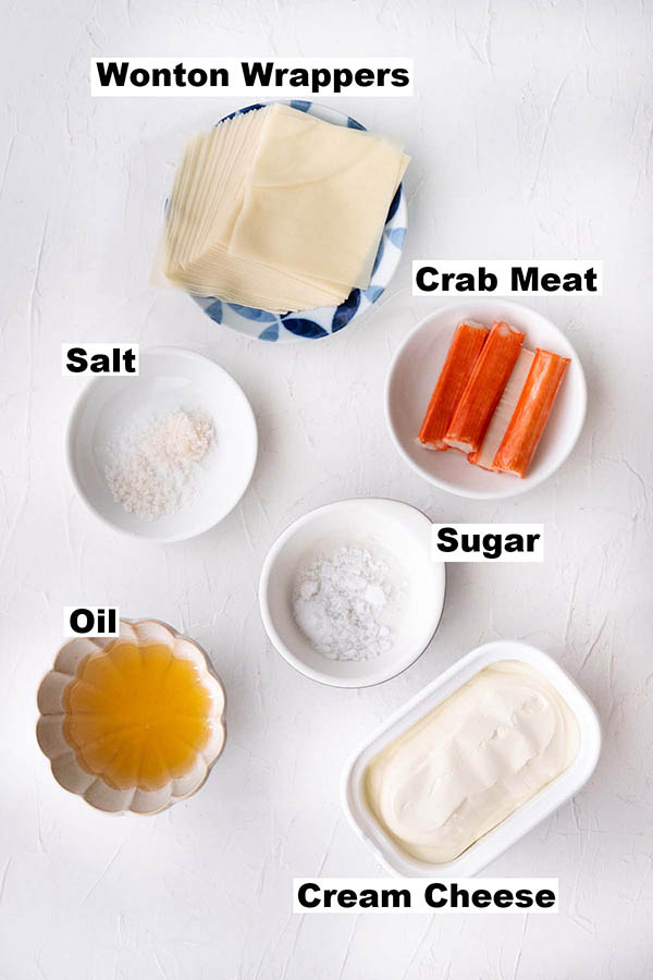 Ingredients for crab rangoon, such as wonton wrappers, crab meat, salt, sugar, oil and cream cheese.