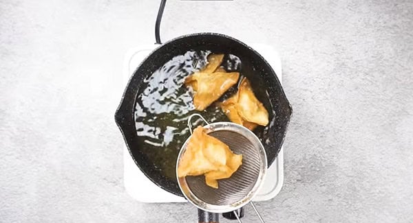 This image shows the Crab Rangoon being removed from the hot oil.
