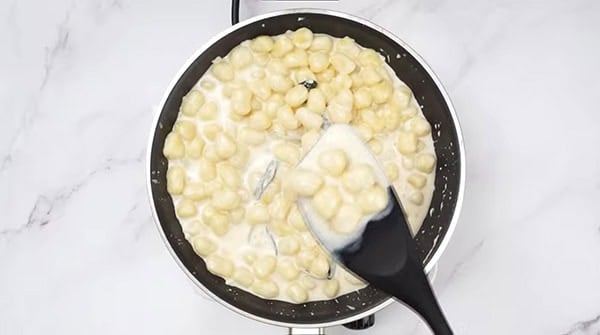 This image shows the chicken broth and whipping cream added into the skillet.