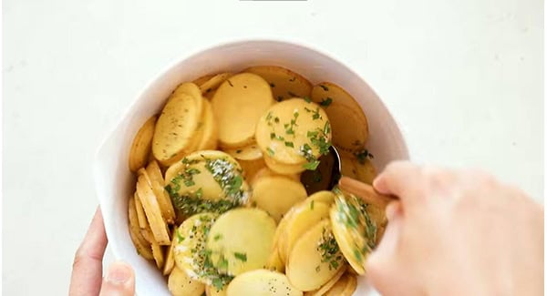 This image shows the Potatoes being coated with the other ingredients.