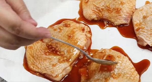 This image shows the marinated chicken on a baking sheet.
