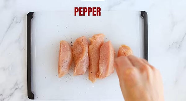 This image shows the Chicken tenders being seasoned.