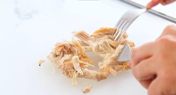 This image shows the chicken tenders being shredded. 