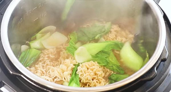This image shows the Bak Choy being added into the Instant Pot.