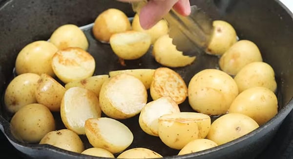 This image shows the potatoes being cooked in a pan.