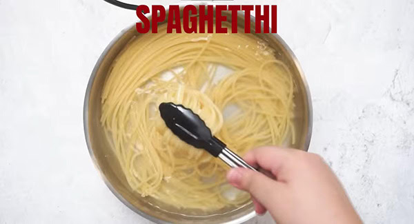 This image shows the pasta being cooked in a pot of water.