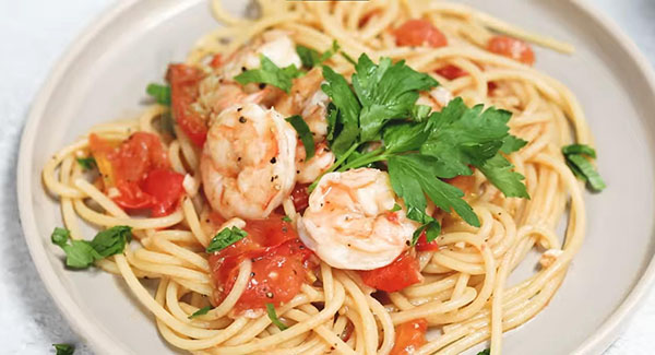 This image shows the Italian Shrimp Pasta topped with Parsley and ready to be served.