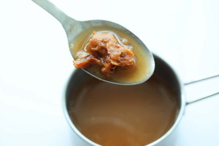 Tamarind water and tamarind pulps in a spoon. 