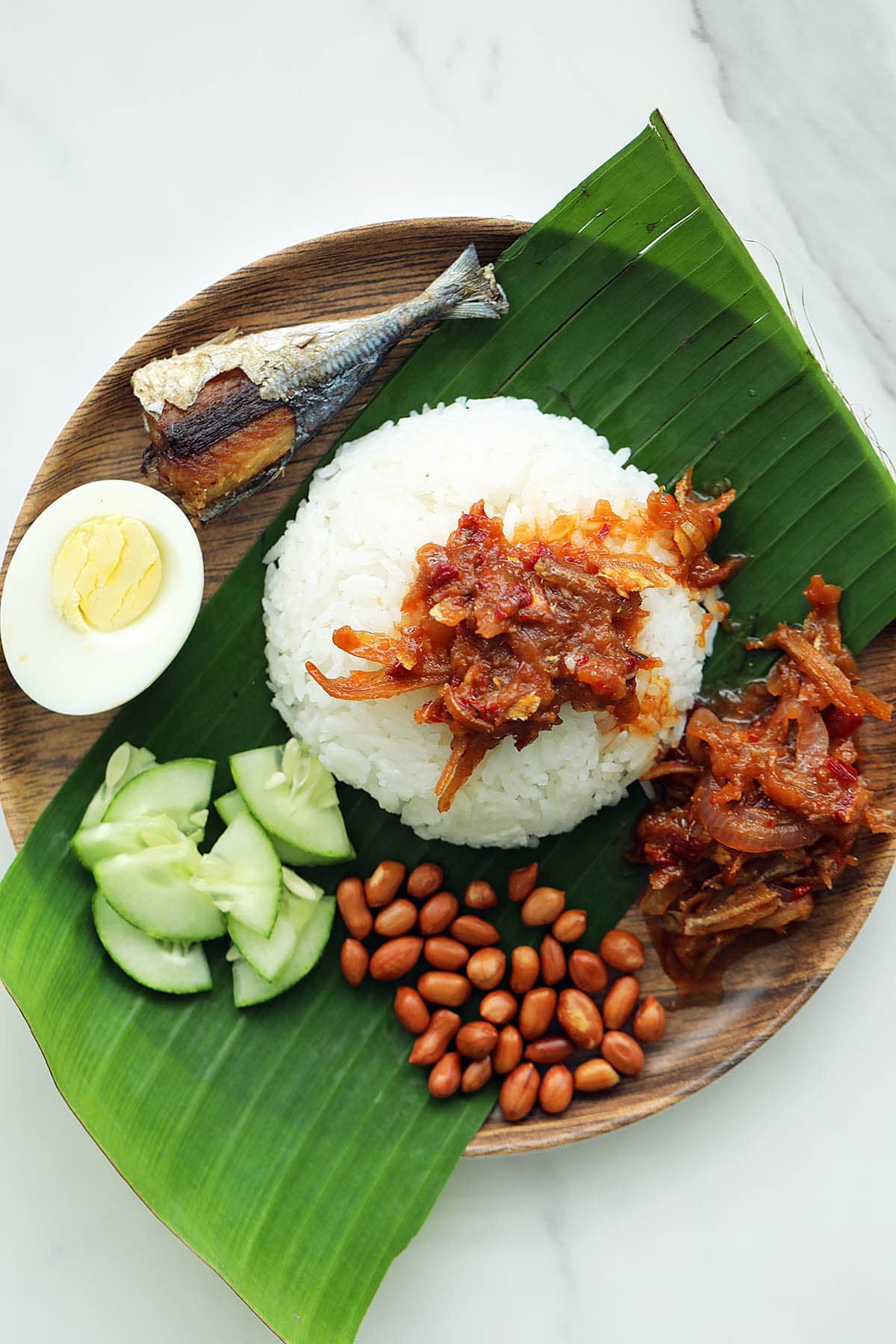 Malaysian coconut milk rice, served with sambal anchovies, roasted peanuts, hard-boiled egg and cucumber on banana leaf.