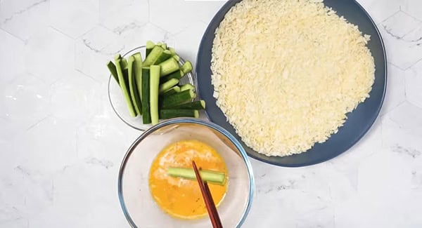 This image shows the Zucchini strips being mixed with eggs and panko.