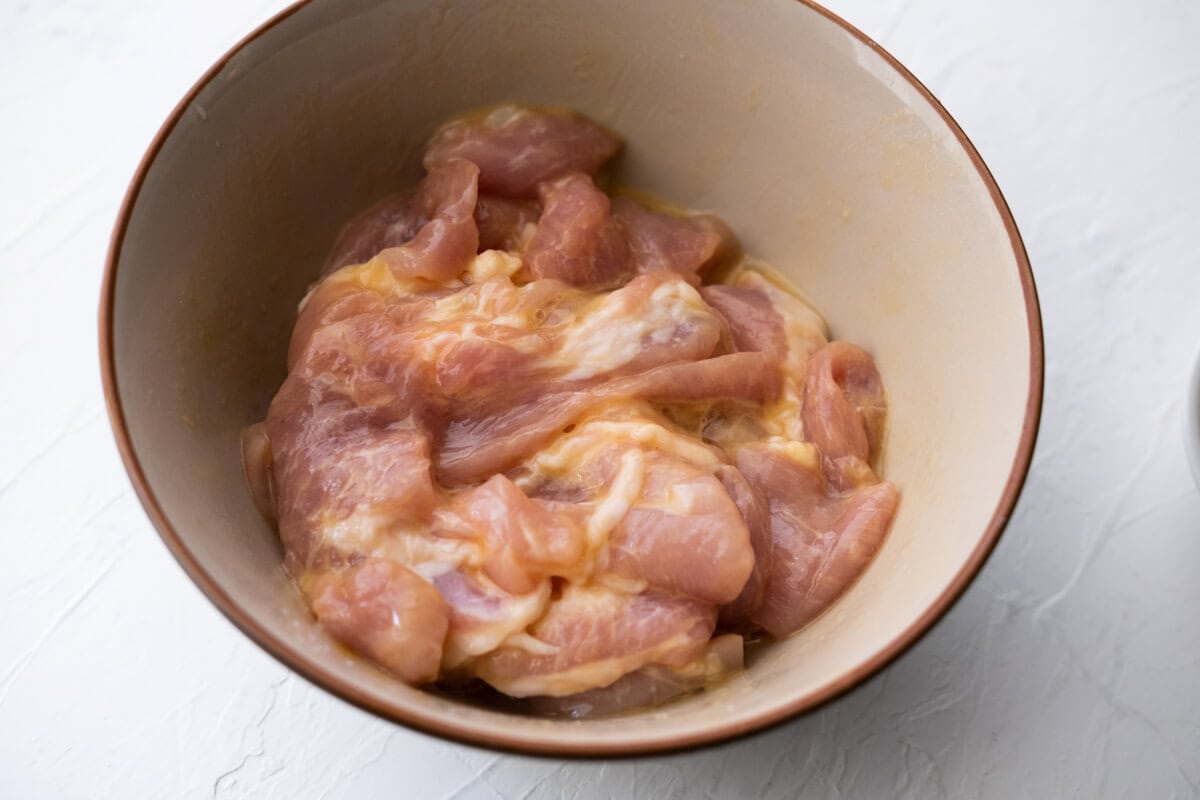 Marinating pork in a bowl with Chinese pork chops marinade. 