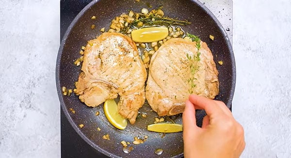 Cooked pork chops in a pan.