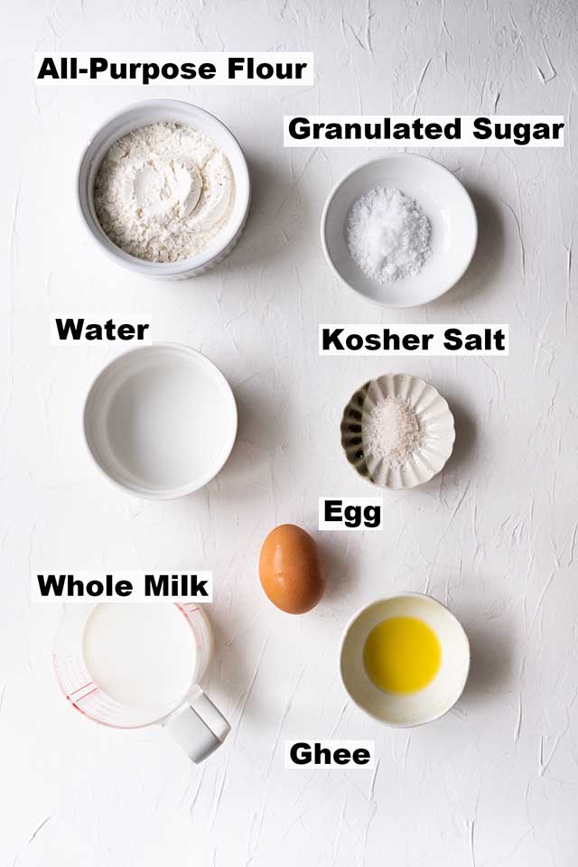 This image contains ingredients such as all-purpose flour, granulated sugar, water, kosher salt, egg, whole milk and ghee to make Roti Canai.