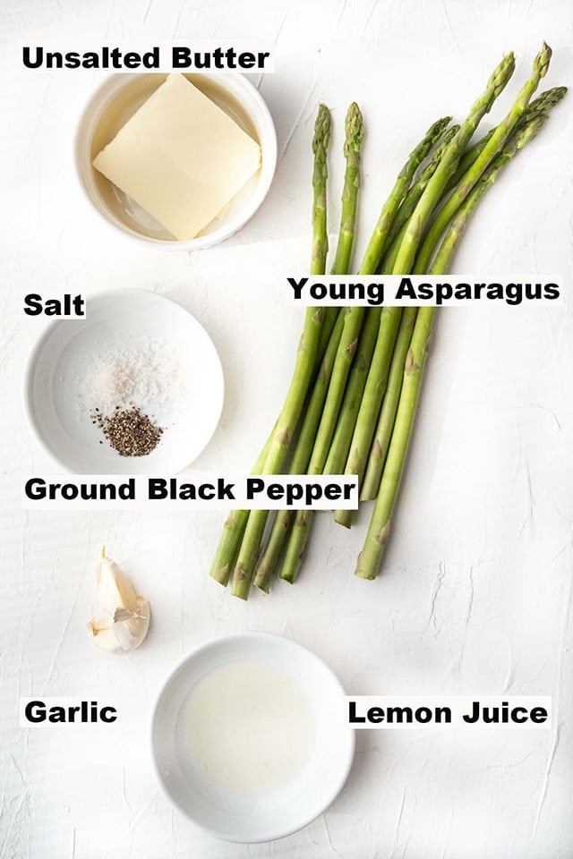 This image contains ingredients such as unsalted butter, young asparagus, salt, ground black pepper, garlic and lemon juice which are needed to make the Garlic Butter Sautéed Asparagus recipe.