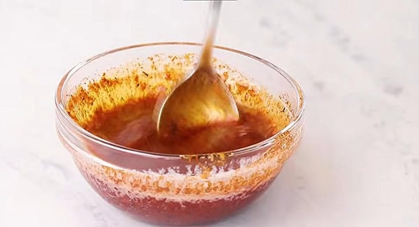 Cajun Butter sauce being mixed in a bowl.