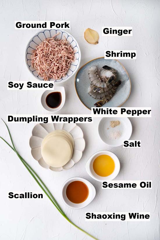 This image consist of ingredients such as ground pork, shrimp, ginger, soy sauce, white pepper, dumpling wrappers, salt, sesame oil, Shaoxing wine and scallion are needed to make the Steamed Dumplings recipe.