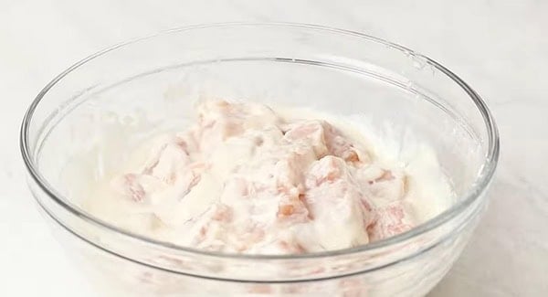 Raw chicken pieces combined with the batter.