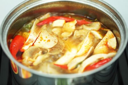 Tom Yum soup boiling in a pot. 