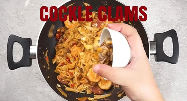 Cockle clams are added to the noodles. 