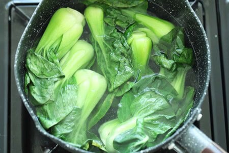 Blanching and cooking Chinese greens bok choy in a pot of boiling water. 