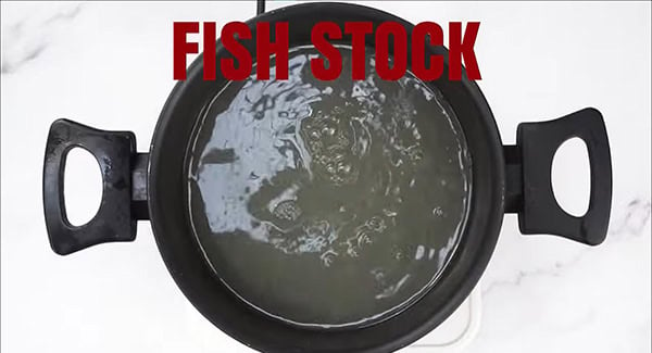 Fish stock in a soup pot. 