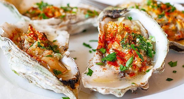 Char grilled oysters on a plate. 