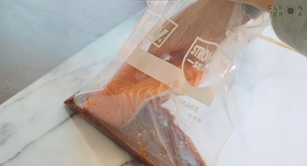 Salmon fillet placed inside a zip lock bag with the salmon glaze ingredients. 