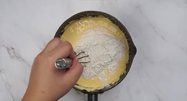 Egg yolks, lemon juice and salt added into the cream cheese mixture and is mixed using a whisk. 