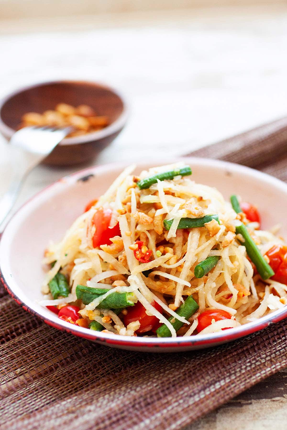 Spicy papaya salad with dried shrimp and Thai salad dressing on plate.  