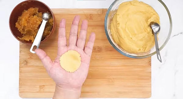 Flattened pineapple cookie dough on a palm. 