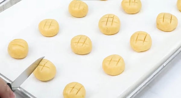 Pineapple cookies with criss-cross shape on top on a baking sheet. 