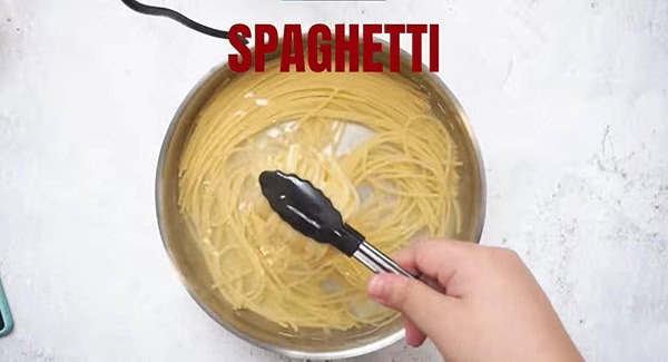 Al dente spaghetti noodles a pot of hot water. 