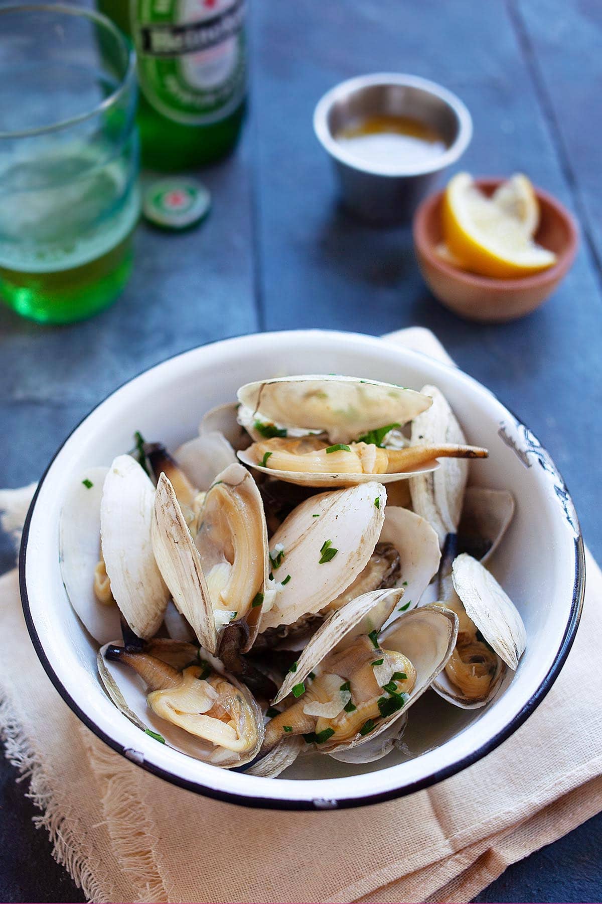 Homemade New England steamers (soft shell clams) with garlic herb butter served in a bowl. 